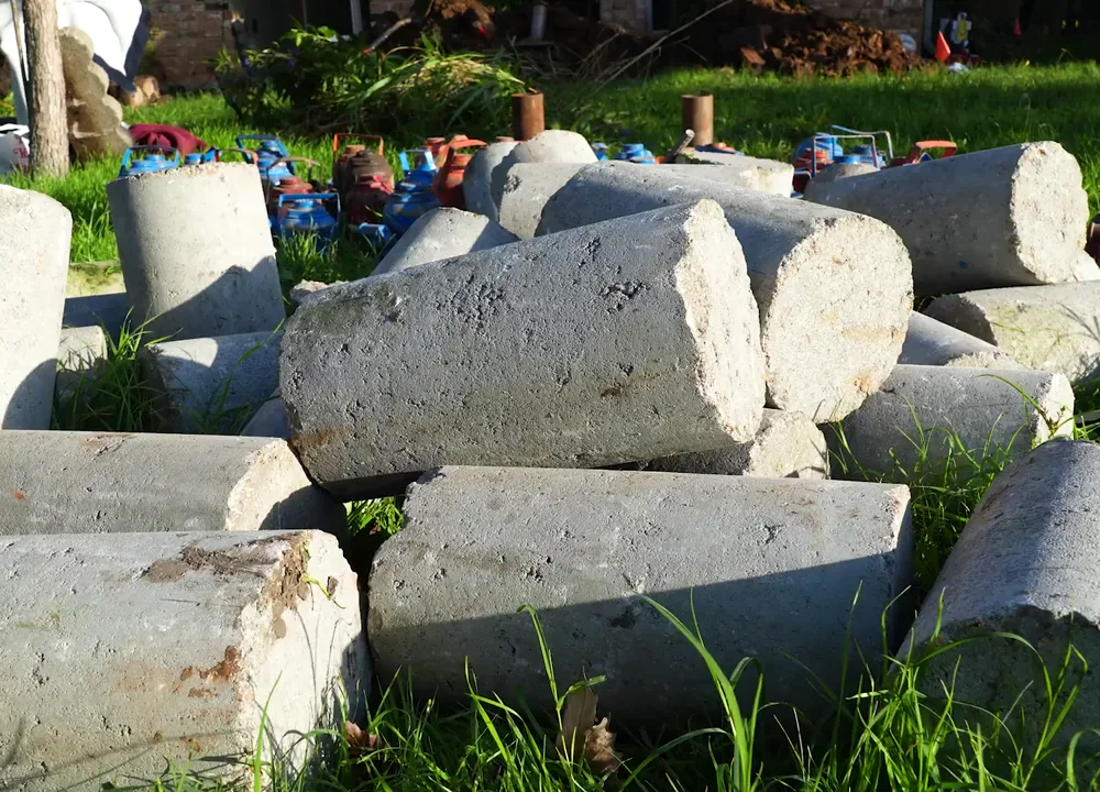 Concrete pier segments and hydraulic press jacks staged for a Pflugerville foundation repair
