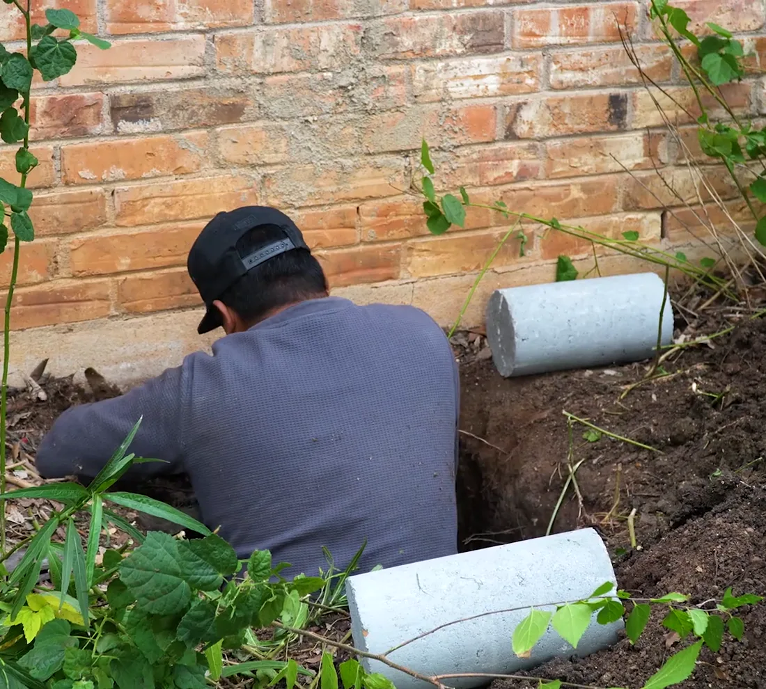 Bats Foundation Repair technician installing concrete piers along the foundation of a Central Texas home